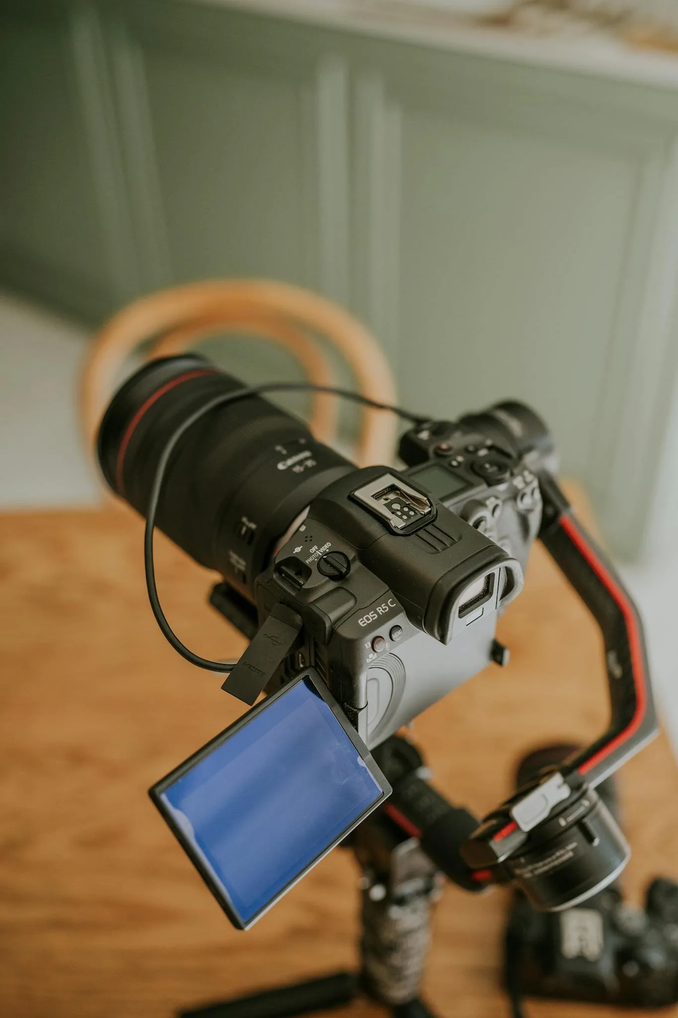 DSLR camera mounted on tripod with open screen indoors, perfect for videography setup visuals.