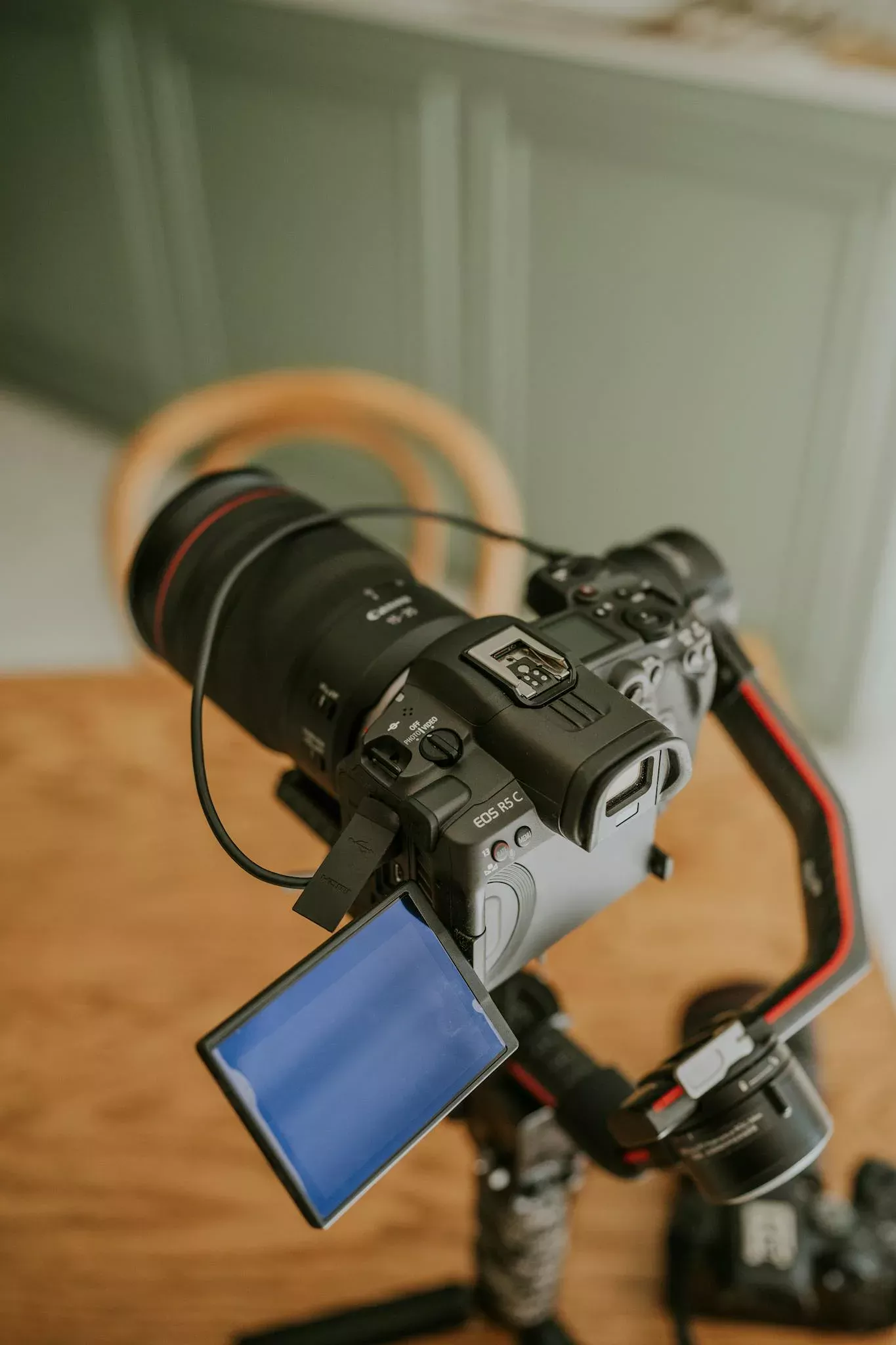 DSLR camera mounted on tripod with open screen indoors, perfect for videography setup visuals.